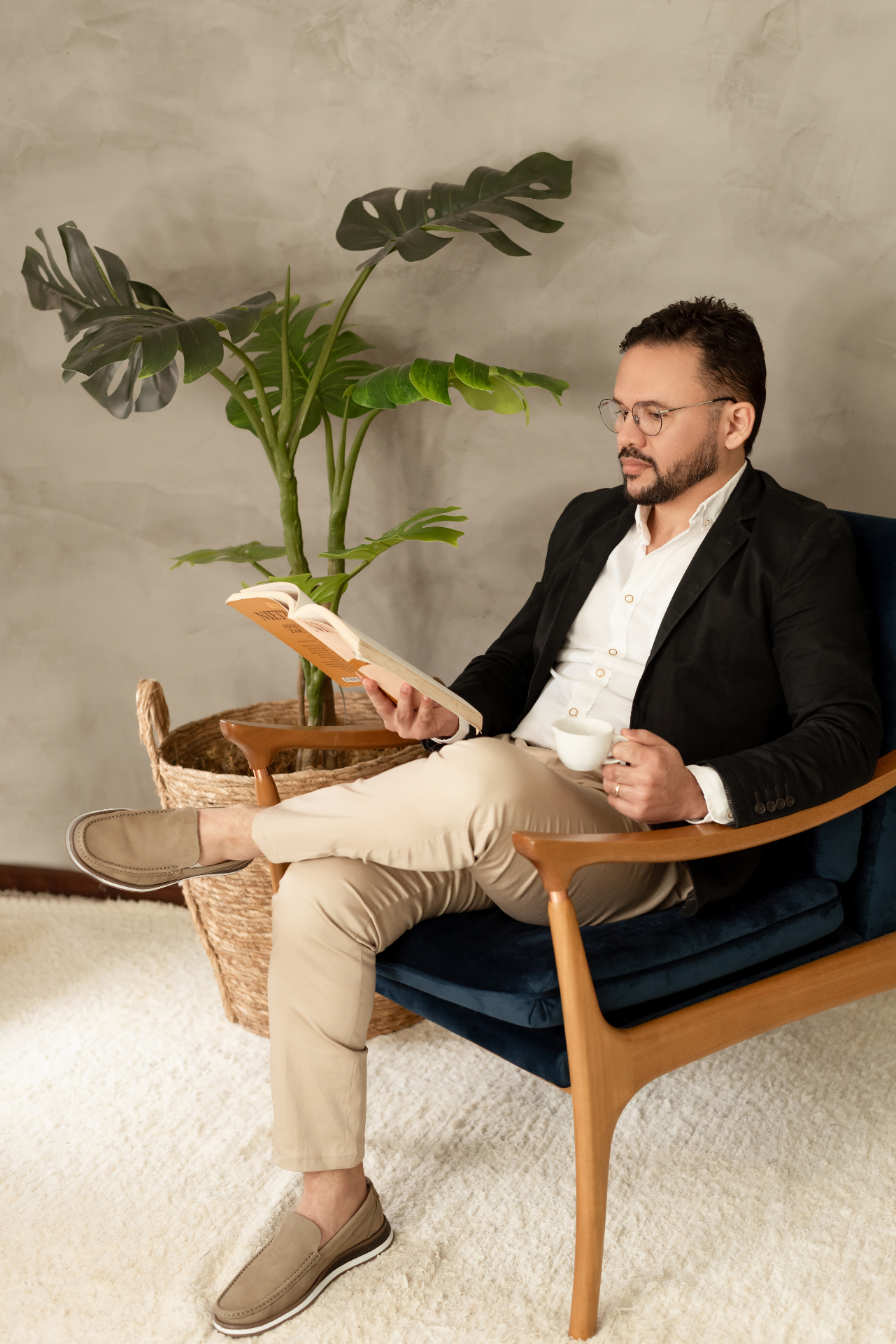 Roberlan Matos no consultório, com um livro e uma xícara de café